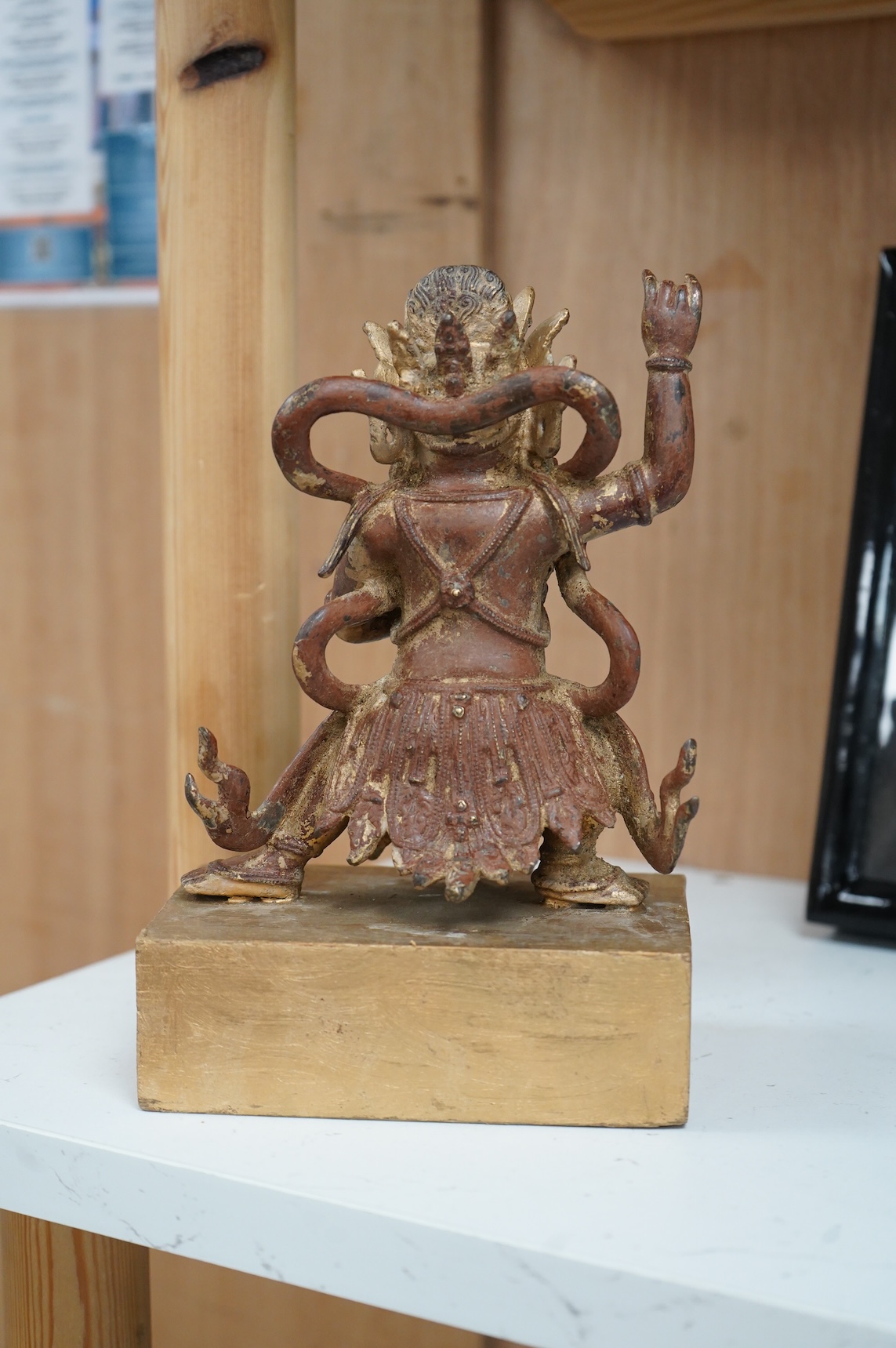 A Buddhist gilt bronze figure of Vaishravana, possibly Tibetan, 21 cm including wooden stand.